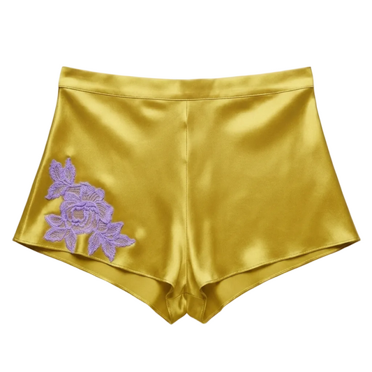 Gold satin shorts with a purple floral lace applique on the left leg, elastic back waist