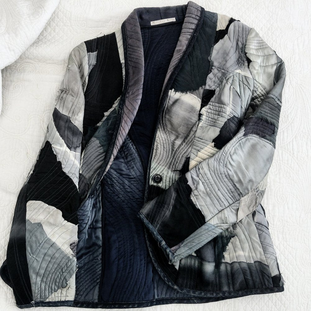 Black And Grey Quilted Jacket On Bed 